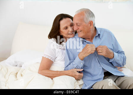 Coppia senior abbracciando sul letto Foto Stock