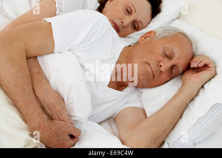 Coppia senior dormire nel letto Foto Stock