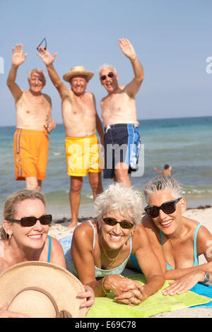 Senior amici rilassante sulla spiaggia Foto Stock
