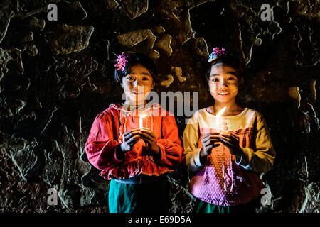 Asian Girls portando candele accese in tempio Foto Stock