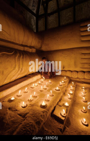 Monaco asiatici accendendo candele nel tempio Foto Stock