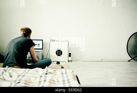 Uomo caucasico utilizzando computer portatile in camera da letto Foto Stock