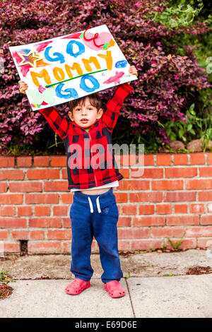 Razza mista boy holding andare mamma andare a firmare Foto Stock