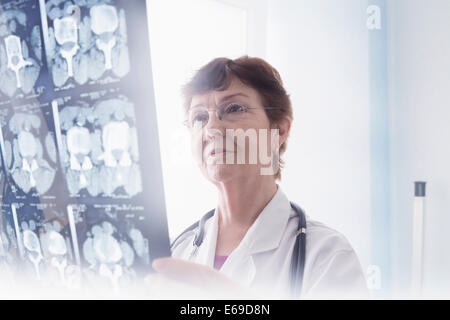 Medico di origine ispanica esaminando i raggi x in office Foto Stock