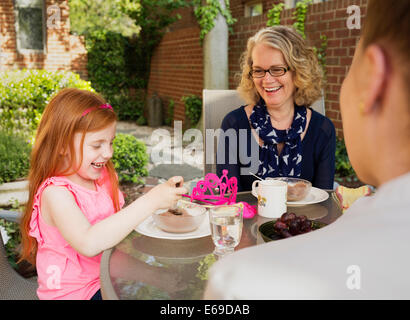 Famiglia caucasica mangiare insieme nel cortile posteriore Foto Stock