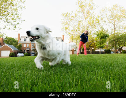 La donna caucasica giocando con il cane in posizione di parcheggio Foto Stock