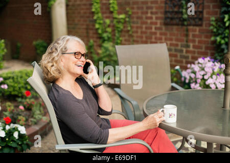 La donna caucasica parlando al cellulare all'aperto Foto Stock