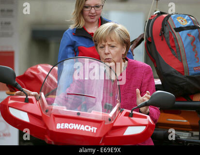 Bonn, Germania. 19 Ago, 2014. Il cancelliere tedesco Angela Merkel siede su un veicolo di soccorso del soccorso di montagna a Bonn, Germania, 19 agosto 2014. Il cancelliere tedesco ha visitato l'Ufficio federale della protezione civile e di assistenza di emergenza per conoscere il lavoro di ufficio e dell'Agenzia federale per il rilievo tecnico (THW). Foto: OLIVER BERG/DPA/Alamy Live News Foto Stock