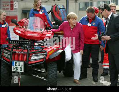 Bonn, Germania. 19 Ago, 2014. Il cancelliere tedesco Angela Merkel si sfilaccia un veicolo di soccorso del soccorso di montagna a Bonn, Germania, 19 agosto 2014. Il cancelliere tedesco ha visitato l'Ufficio federale della protezione civile e di assistenza di emergenza per conoscere il lavoro di ufficio e dell'Agenzia federale per il rilievo tecnico (THW). Foto: OLIVER BERG/DPA/Alamy Live News Foto Stock