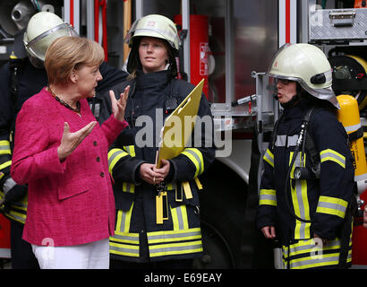 Bonn, Germania. 19 Ago, 2014. Il cancelliere tedesco Angela Merkel (L) parla di volontari femmina vigili del fuoco a Bonn, Germania, 19 agosto 2014. Il cancelliere tedesco ha visitato l'Ufficio federale della protezione civile e di assistenza di emergenza per conoscere il lavoro di ufficio e dell'Agenzia federale per il rilievo tecnico (THW). Foto: OLIVER BERG/DPA/Alamy Live News Foto Stock