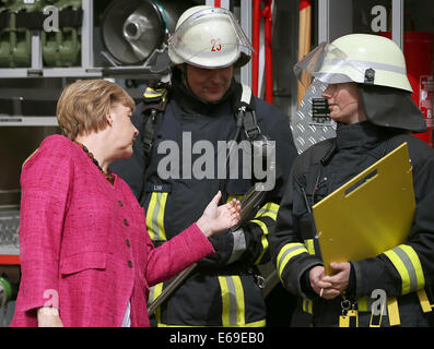 Bonn, Germania. 19 Ago, 2014. Il cancelliere tedesco Angela Merkel (L) ispeziona equioment volontario dei vigili del fuoco a Bonn, Germania, 19 agosto 2014. Il cancelliere tedesco ha visitato l'Ufficio federale della protezione civile e di assistenza di emergenza per conoscere il lavoro di ufficio e dell'Agenzia federale per il rilievo tecnico (THW). Foto: OLIVER BERG/DPA/Alamy Live News Foto Stock