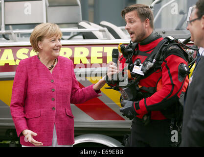 Bonn, Germania. 19 Ago, 2014. Il cancelliere tedesco Angela Merkel parla di un rescue diver a Bonn, Germania, 19 agosto 2014. Il cancelliere tedesco ha visitato l'Ufficio federale della protezione civile e di assistenza di emergenza per conoscere il lavoro di ufficio e dell'Agenzia federale per il rilievo tecnico (THW). Foto: OLIVER BERG/DPA/Alamy Live News Foto Stock