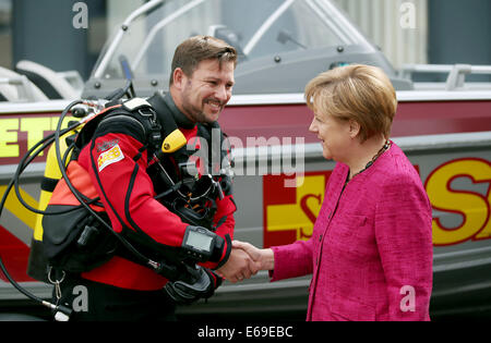 Bonn, Germania. 19 Ago, 2014. Il cancelliere tedesco Angela Merkel saluta un rescue diver a Bonn, Germania, 19 agosto 2014. Il cancelliere tedesco ha visitato l'Ufficio federale della protezione civile e di assistenza di emergenza per conoscere il lavoro di ufficio e dell'Agenzia federale per il rilievo tecnico (THW). Foto: OLIVER BERG/DPA/Alamy Live News Foto Stock