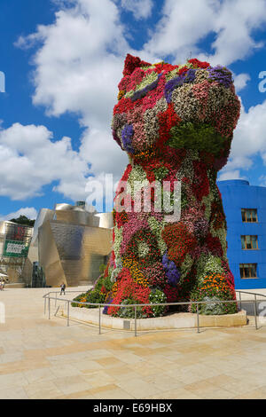 BILBAO, Spagna - 10 luglio 2014: persone non identificate hanno vicino l'opera d'arte 'Cucciolo" di Jeff Koons di fronte al famoso museo Guggenheim Foto Stock