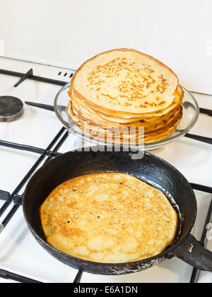 Frittella fritto in padella e pila di pancakes preparati Foto Stock