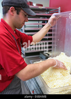 Titolare di una piccola azienda di Pizza Shop (pizzeria) ripieno di formaggio grattugiato bin, STATI UNITI D'AMERICA Foto Stock