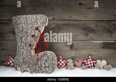 Xmas greeting card con santa boot in rosso e di colore bianco su sfondo di legno con la neve. Idea per la decorazione di Natale. Foto Stock