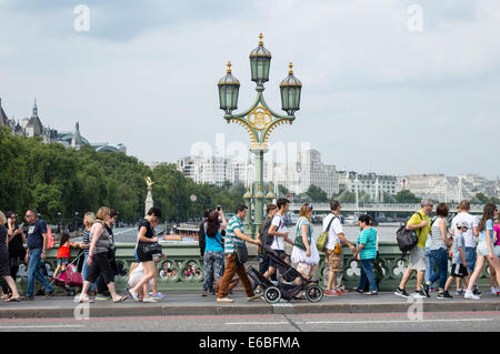 I turisti attraversando a piedi il ponte di Westminster Londra Foto Stock