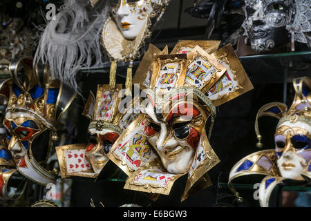 Un Carnevale jester maschera in una vetrina di un negozio di visualizzare su una delle principali arterie di grande traffico pedonale a Venezia. Foto Stock