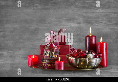 Quattro red burning avvento candlesand presenta sul grigio di una squallida xmas sfondo. Foto Stock