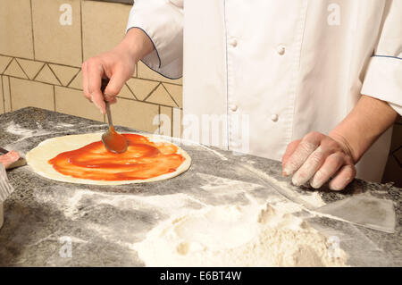 Close up di Chef la realizzazione di una base per pizza Foto Stock