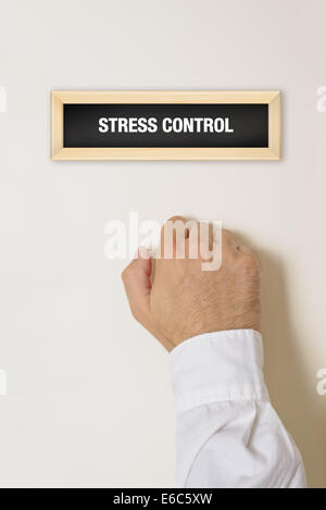 Mano maschio a bussare alla porta di controllo dello stress in ufficio. Foto Stock