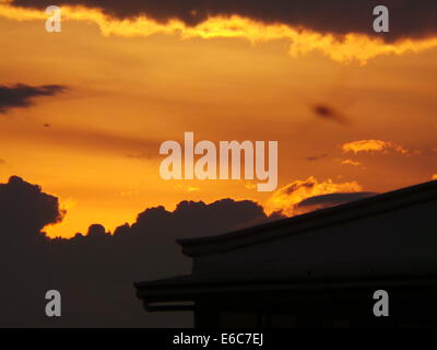 Quezon City, Filippine. 20 Agosto, 2014. Tramonto a Quezon City Dopo forti piogge monsoniche intorno a 2:30 pm che durò meno di un'ora che ha causato le inondazioni in Panay Avenue. Il drenaggio / di fognature di Panay Avenue sono state molte volte riabilitato nel 2013 in modo che possa sopportare il notevole volume di acqua delle piogge ma purtroppo non riuscita. Tonnellate di rifiuti che sporchi il drenaggio è stata osservata dopo il diluvio cessa. Credito: Sherbien Dacalanio / Alamy Live News Foto Stock