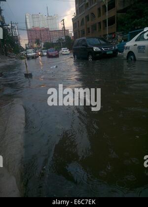 Quezon City, Filippine. 20 Agosto, 2014. I veicoli sono visibili passando attraverso l'allagato Panay Avenue in Quezon City. Forti piogge monsoniche intorno a 2:30 pm che durò meno di un ora causato inondazioni. Il drenaggio / di fognature di Panay Avenue sono state molte volte riabilitato nel 2013 in modo che possa sopportare il notevole volume di acqua delle piogge ma purtroppo non riuscita. Tonnellate di rifiuti che sporchi il drenaggio è stata osservata dopo il diluvio cessa. Credito: Sherbien Dacalanio / Alamy Live News Foto Stock