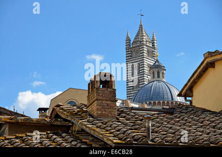 Siena, Toscana, Italia, Europa - La torre campanaria del Duomo di Siena cattedrale attraverso tetti rossi Foto Stock