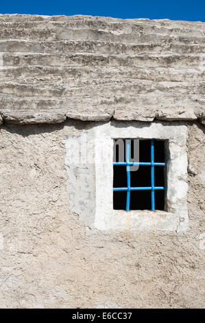 Una finestra blu con barre di acciaio sul Mediterraneo casa di pietra Foto Stock