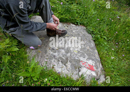 Trekker facendo il suo lacci. Foto Stock