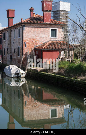 Casa e barca riflessa nel canale che conduce alla Cattedrale di Santa Maria Assunta a Torcello. Foto Stock