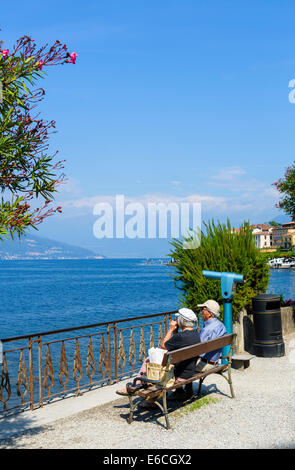 Coppia di anziani seduto a mangiare il pranzo sul lungolago di Bellagio, Lago di Como, Lombardia, Italia Foto Stock