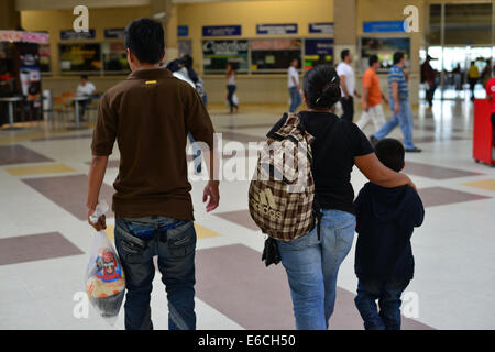 San Pedro Sula, Cortez, Honduras. 28 Luglio, 2014. Sandra Herrera e suoi figli Alex Fernando, 17 e John Terry, 5, a piedi un contatore bus a San Pedro Sula per acquistare un biglietto torna alla capitale dell Honduras Tegucigalpa. Fernando è stato espulso dal Messico ore prima. Egli aveva acquisito un prestito di $ 250, per pagare il viaggio. © Miguel Juarez Lugo/ZUMA filo/Alamy Live News Foto Stock