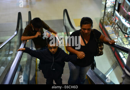 San Pedro Sula, Cortez, Honduras. 28 Luglio, 2014. Sandra Herrera e suoi figli John Terry, 5, e Alex Fernando, 17, testa attraverso una stazione degli autobus sulla loro strada di casa a Tegucigalpa dopo Alex è stato arrestato dalla polizia messicana e deportati durante un tentativo di raggiungere gli Stati Uniti © Miguel Juarez Lugo/ZUMA filo/Alamy Live News Foto Stock