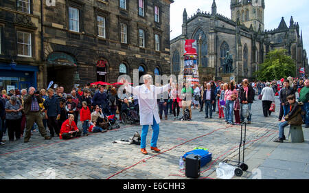 Gli artisti interpreti o esecutori della frangia di intrattenere e promuovere il loro show in High Street, Edimburgo Foto Stock