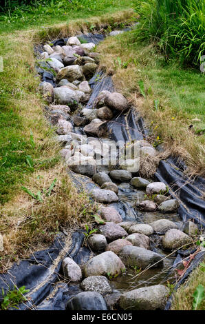 Reso stagno artificiale di flusso e decorativi giardino paesaggistico Foto Stock