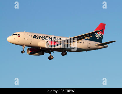 Aria Serbia Airbus A319 sull approccio finale al tramonto contro un cielo blu chiaro Foto Stock