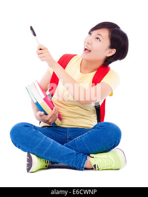 Studente di bella ragazza asiatica tenendo la penna e seduto sul pavimento Foto Stock