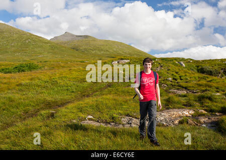 Un ragazzo adolescente salendo ben di più, un Munro sull'Isle of Mull, Scotland, Regno Unito. Foto Stock