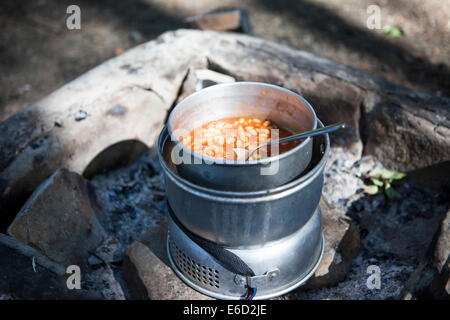 Camping cucina con fagioli all'aperto nella bella luce solare. Foto Stock