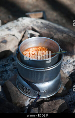 Camping cucina con fagioli all'aperto nella bella luce solare. Foto Stock