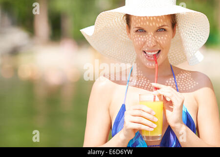 Donna in bikini bere il succo d'arancia Foto Stock