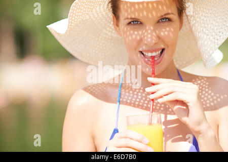 Ritratto di una donna in bikini di bere succo di frutta Foto Stock