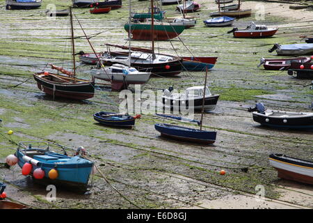 Una flottiglia di piccole imbarcazioni da pesca nel porto di Mousehole attesa per la marea di venire a. Foto Stock