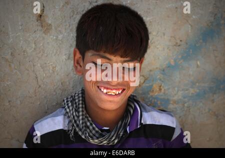 A Kabul, Afghanistan. 21 Ago, 2014. Un bambino afghano sorride al di fuori di una tenda in un campo profughi a Kabul, in Afghanistan, il 21 agosto 2014. Credito: Ahmad Massoud/Xinhua/Alamy Live News Foto Stock