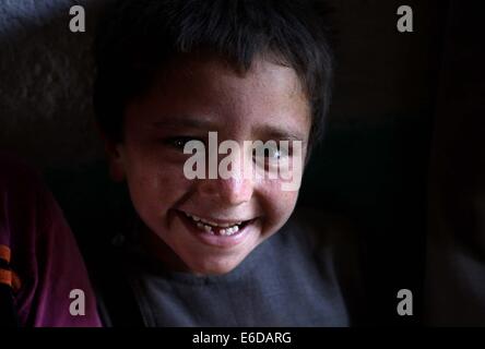 A Kabul, Afghanistan. 21 Ago, 2014. Un bambino afghano sorride all'interno di una tenda in un campo profughi a Kabul, in Afghanistan, il 21 agosto 2014. Credito: Ahmad Massoud/Xinhua/Alamy Live News Foto Stock