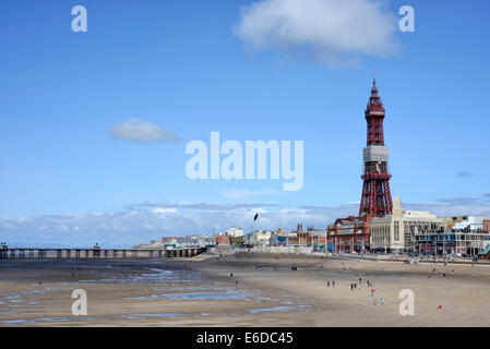 La Blackpool Tower in Lancashire, Inghilterra vista lungo la spiaggia di sabbia dal molo centrale Foto Stock