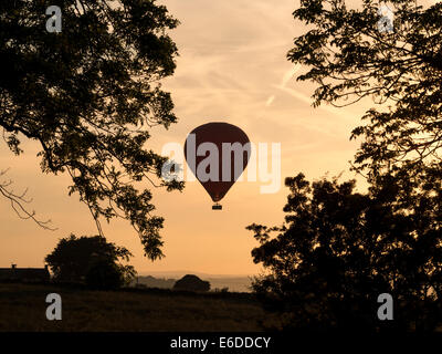 Un palloncino per il trasporto di passeggeri viene a terra su campi al crepuscolo, Derbyshire, Regno Unito Foto Stock