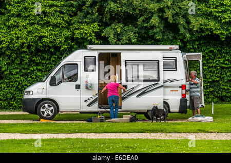 Un giovane e il loro cane con il loro camper su un caravan club campeggio pitch in Inghilterra, Regno Unito. Foto Stock